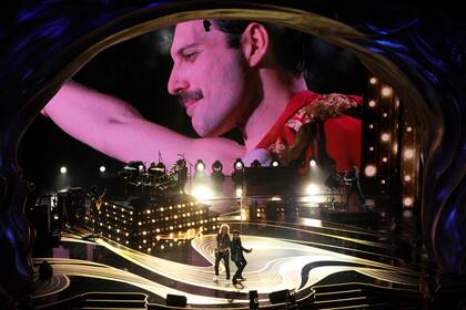 Queen con Adam Lambert y una imagen de Freddie Mercury de fondo