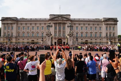 Las multitudes observan la ceremonia de cambio de guardia en el Palacio de Buckingham en Londres, en el primer aniversario de la muerte de la reina Isabel II