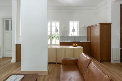 “Queríamos que la cocina estuviera solo para lo que se la necesita, sin alterar la estética del ambiente principal. Por eso, mantiene el piso, las molduras y la altura del techo”.