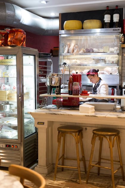 Quesos, embutidos y otros ingredientes a la vista en la cocina, integrada al salón.