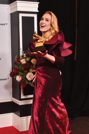 Radiante, Adele celebró el Grammy que ganó en la categoría Mejor Interpretación Pop Solista por su tema “Easy On Me”. Para la cita, llevó un Louis Vuitton de terciopelo con gran escote y maxivolados y pendientes de diamantes.