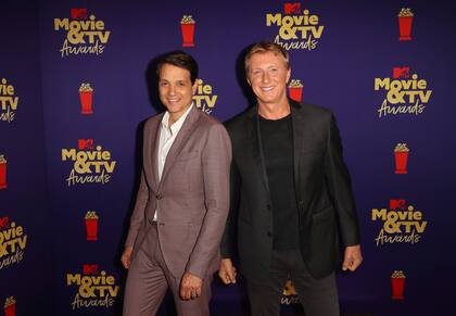 Ralph Macchio y William Zabka, sonrientes, aunque con las manos vacías