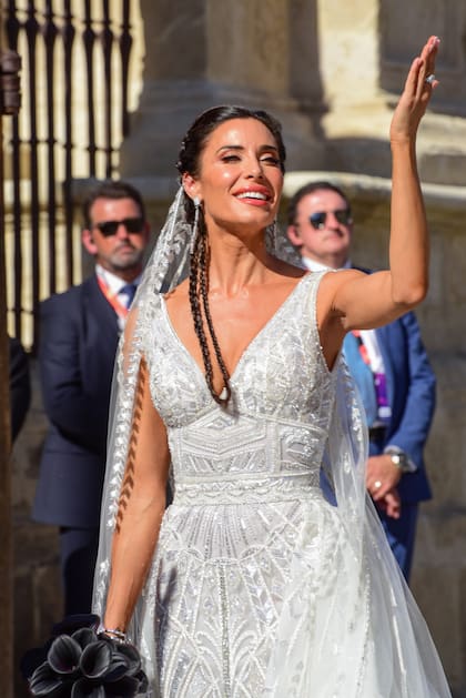 El vestido de la novia era un diseño del libanés Zuhair Murad bordado con aplicaciones, pequeños espejos y abalorios, con pronunciado escote y una sobrefalda de la que nacía una cola lateral.