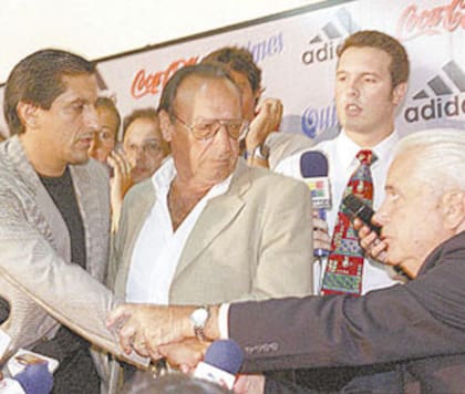 Ramón Díaz estrecha la mano con Alfredo Davicce; en el medio, observa David Pintado