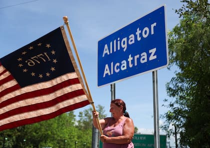 Rana Mourer ondea una bandera estadounidense fuera del centro de detención de inmigrantes conocido como “Alcatraz de los Caimanes” en la instalación de Entrenamiento y Transición de Dade-Collier, el sábado 12 de julio de 2025 en Ochopee, Florida