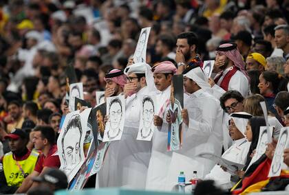 Reacción de qataríes a la crítica de los futbolistas alemanes: sostienen retratos de Mesut Özil, el germano de origen turco que dejó el seleccionado por sentirse hostigado y víctima de racismo.