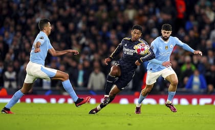 Real Madrid's Jude Bellingham, centre, is challenged by Manchester City's Rodri, left and Josko Gvardiol,  during the Champions League quarterfinal, second leg soccer match between Manchester City and Real Madrid, at the Etihad Stadium, in Manchester, England. Wednesday April 17, 2024. (Mike Egerton/PA via AP)