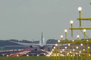 Rear view of Boeing of Unnited Airlines landing at Schiphol airport at sunset. Shot from the beginning of runway.