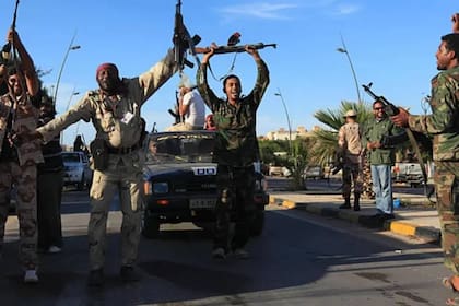 Rebeldes celebran la muerte de Muammar Khadafy en las calles de Sirte, en Libia