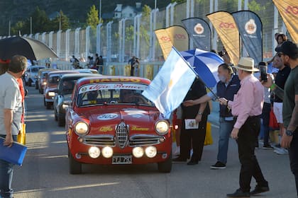 Recibe la bandera argentina, señal de partida, el Alfa Romeo Giulietta de 1961 de Carlos Hidalgo y Juan Villarino en la calle de boxes de Potrero de los Funes.