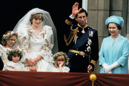 Recién casados, los príncipes de Gales -escoltados por la reina Isabel II y sus damas de honor- saludan desde el balcón de Buckingham. Corría julio de 1981.
