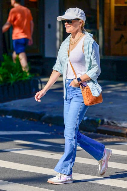 Reese Witherspoon eligió un look súper canchero para ir de compras con su hijo. La actriz combinó unos jeans azules con una musculosa básica blanca y una camisa rayada que usó desabrochada. Su cartera en color suela le dio un toque de color a su outfit