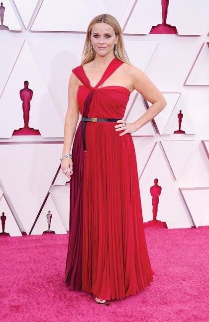 Reese Witherspoon lució un traje
de noche vaporoso, con escote asimétrico y cinturón, de Dior.
Completó su outfit con anillos con rubíes y un brazalete
realizado con perlas cultivadas.