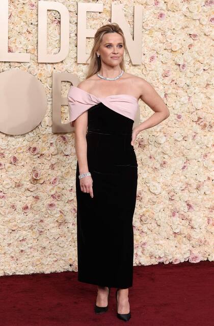 Reese Witherspoon, muy elegante, con un diseño dama de honor en negro con un detalle rosa en el escote