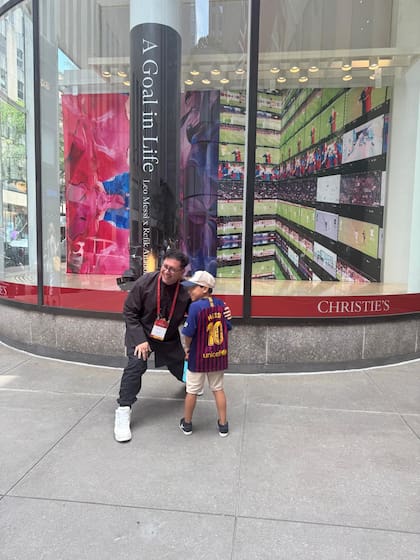 Refik Anadol posa con un nene vestido con la camiseta de Messi en la sede de Christie's en Nueva York