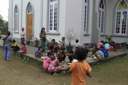 Refugiados de la etnia kachin comen en un campo de refugiados que se montó alrededor de una iglesia