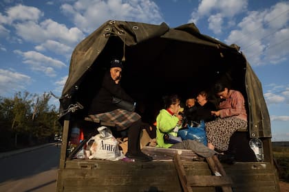 Refugiados sentados en la parte trasera de un camión con sus pertenencias cargadas cerca de Kornidzor el 28 de septiembre de 2023. (Foto de ALAIN JOCARD / AFP)