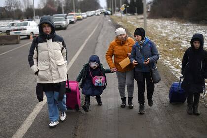 Una familia ucraniana camina hacia el cruce fronterizo Medyka-Shehyni entre Ucrania y Polonia mientras huyen del conflicto en su país, cerca de la aldea ucraniana de Tvirzha, a unos 20 km de la frontera