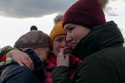 Refugiados ucranianos lloran al reunirse en el cruce fronterizo de Medyka, Polonia.