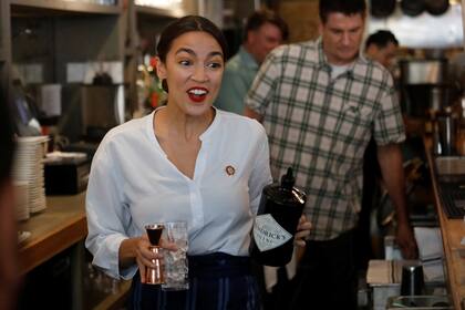 Rep. Alexandria Ocasio-Cortez (D-NY) walks to make a drink in support of One Fair Wage, a policy that would allow tipped workers to receive full minimum wage plus their tips in New York, at The Queensboro restaurant in the Queens borough of New York, U.S., May 31, 2019. REUTERS/Shannon Stapleton TP