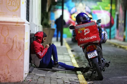 Los repartidores anoche en una zona de alta demanda gastronómica, a la espera para levantar pedidos y partir a entregarlos
