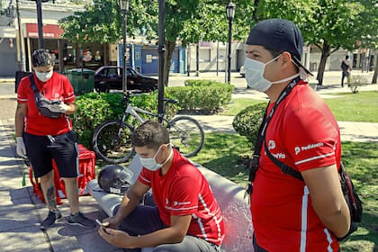 Trabajadores de delivery circulan con barbijos, en Pilar