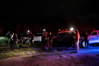 Reporteros de noticias cerca de la escena donde se descubrió un tractor-remolque con migrantes dentro en las afueras de San Antonio, Texas, el 27 de junio de 2022. 