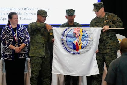 Representantes del ambos ejércitos despliegan la bandera del ejercicio militar conjunto llamado "Balikatan", palabra tagala que significa "hombro con hombro", durante las ceremonias de apertura en el cuartel militar de Camp Aguinaldo el martes 11 de abril de 2023, en Quezon City, Filipinas.