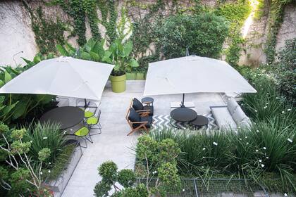 Reproducir en exteriores un comedor y un living, rodeados del verde en movimiento que nos proporcionan los Dietes grandiflora. Sombrillas cuadradas para que, en las horas de sol, también pueda aprovecharse al máximo este espacio.