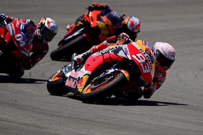 Repsol Honda Teams Spanish rider Marc Marquez (R) competes with Ducatis Italian rider Andrea Dovizioso (L) and Red Bull KTM Factory Racings Spanish rider Pol Espargaro during the MotoGP race of the Spanish Grand Prix at the Jerez racetrack in Jerez de la Frontera on July 19, 2020