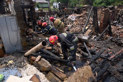 Rescatistas apagan un incendio en una vivienda destruida por un ataque ruso con drones, el jueves 5 de junio en el poblado de Pryluky, Ucrania. (AP Foto/Evgeniy Maloletka)