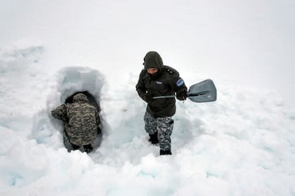 El trabajo en equipo es una de las claves: en este caso, mientras un gendarme cava dentro de la futura cueva, otro va retirando la nieve que saca y la tira más lejos.