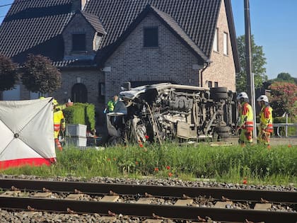 Rescatistas en el lugar de un choque entre un tren y un vehículo en Buggenhout,Bélgica, el martes 26 de mayo de 2026. (AP Foto/Koen Baten)