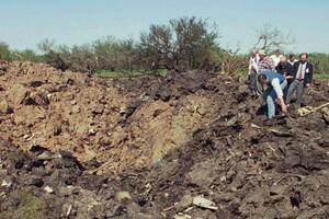 Rescatistas inspeccionan el cráter dejado por el avión al caer