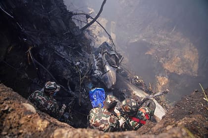 Rescatistas inspeccionan el lugar donde se estrelló un avión en Pokhara el 15 de enero de 2023.