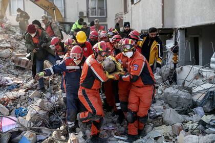 Rescatistas sacan a un migrante sirio de entre los escombros de un edificio destruido en Antioquía, en el sur de Turquía