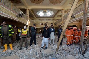 Rescatistas se reúnen mientras llevan a cabo una operación para despejar los escombros y buscar cuerpos en el lugar del atentado suicida del lunes, en Peshawar, Pakistán, martes 31 de enero de 2023.