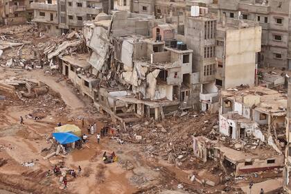 Rescatistas y parientes de víctimas colocan carpas ante edificios derruidos en Derna, Libia, tras graves inundaciones que dejaron destrucción total en varias ciudades el lunes 18 de septiembre de 2023. 