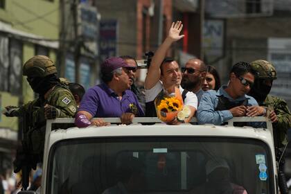 Resguardado por militares y policías, el candidato presidencial Daniel Noboa, de la alianza Acción Democrática Nacional, saluda a sus simpatizantes en un acto de campaña en Quito, Ecuador, el miércoles 11 de octubre de 2023. (AP Foto/Dolores Ochoa)
