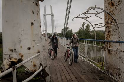 Residentes cruzan un puente sobre el río Siverskyi Donets en la estratégica ciudad de Izium
