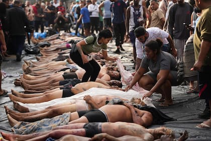 Residentes de la favela Penha identifican a sus familiares en la plaza
(AP Photo/Silvia Izquierdo)