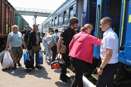 Residentes de la región de Kherson abordan un tren de evacuación. Un tercio de los ucranianos fueron desplazados por la guerra. (Archivo)