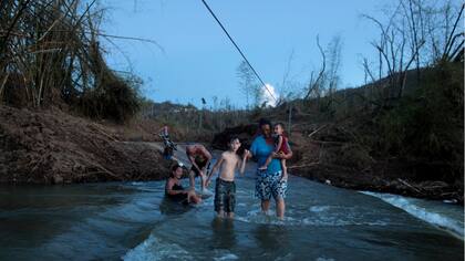 Residentes de San Lorenzo deben cruzar el río como pueden , luego del paso del Huracán Maria destruyera el puente .