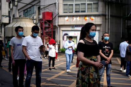Ciudadanos de Wuhan aguardan para un hisopado. La ciudad estuvo aislada y en cuarentena en los primeros meses del año, tras lo cual retomó la actividad