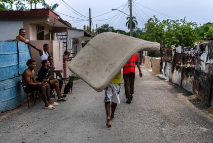 Residentes del barrio de El Fanguito llevan un colchón a un lugar seguro en preparación para la llegada del huracán Ian, en La Habana, Cuba, el lunes 26 de septiembre de 2022.