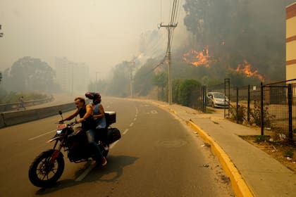 Residentes evacúan entre incendios forestales en Viña del Mar, Chile, el 3 de febrero de 2024. (AP Foto/Esteban Felix, Archivo)