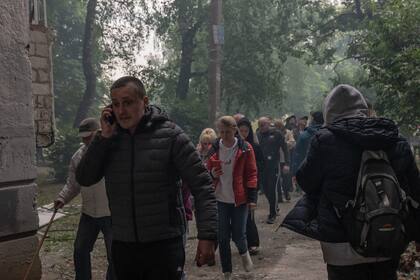 Residentes llevan sus pertenencias mientras se marchan como consecuencia de un ataque con misiles en Kharkiv. Foto: Svet Jacqueline/ZUMA Press Wire/dpa