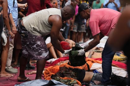 Residentes ponen en un bolso la cabeza de un joven decapitado durante el operativo policial en las favelas de Río de Janeiro