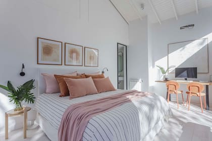 Respaldo, almohadones y manta rosa (Teodolina Deco). Obras (Natural Arts). Sillas naranjas (El Yeite).