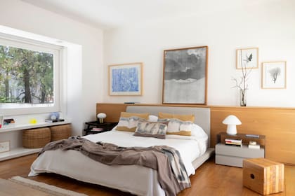 Respaldo continuo en roble (Broca). Por encima, obras azul (Gastón Herrera), blanca y negra (Adam Jeppesen) y dúo floral (Sofía Wiñazki). La linealidad del bajo ventana se aprovechó para bibliotecas y escritorios en todos los cuartos.